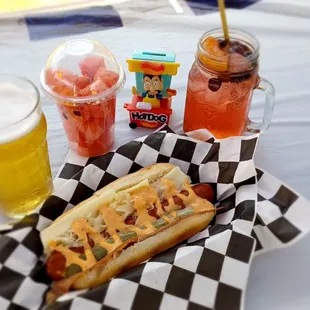 a hot dog and drinks on a picnic table