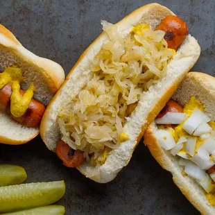 two hot dogs with sauerkraut and pickles
