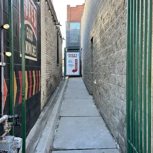 a narrow alley with a sign on the wall