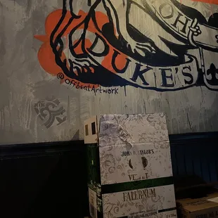 boxes of beer in front of a mural