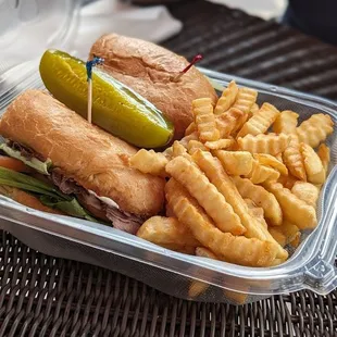 a sandwich with pickle and french fries