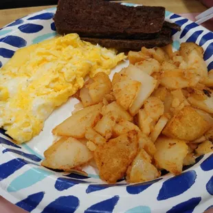 Breakfast platter with scrambled eggs, home fries, scrapple and toast.