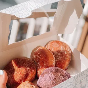 Cinnamon Malasada, 2 sugar Malasada, mango mochi Malasada, ube Malasada (top left to bottom right)