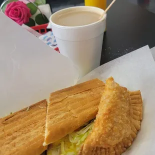 Ham egg and cheese sandwich, chicken empanada and cafe con Leche