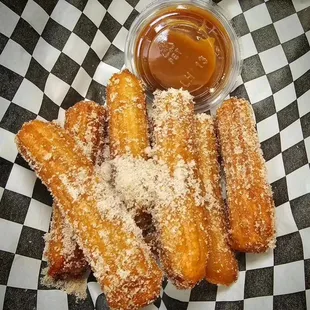 a plate of churros and dipping sauce