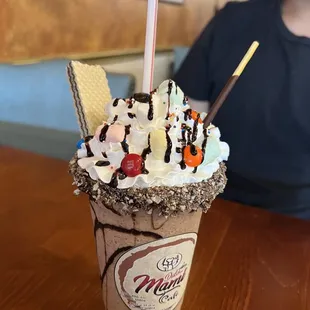 a man sitting at a table with a cup of milkshake