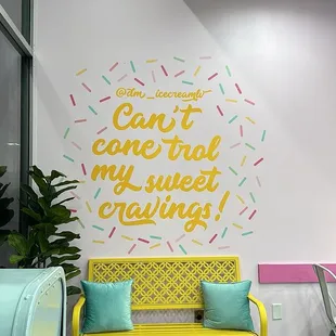  yellow bench in front of a pink wall