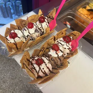 two ice cream sundaes with chocolate and cherries