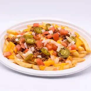 a plate of fries with chili, peppers, and cheese