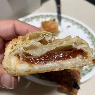 a hand holding a half eaten pastry