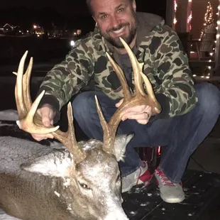 a man posing with a deer