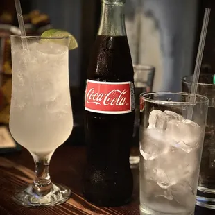 a bottle of coca cola and a glass of water