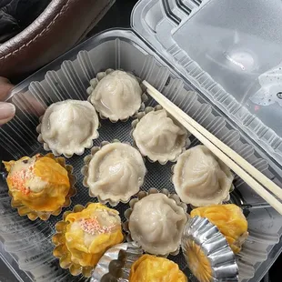 a tray of dumplings with chopsticks