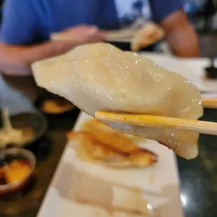 a person holding chopsticks over a plate of food