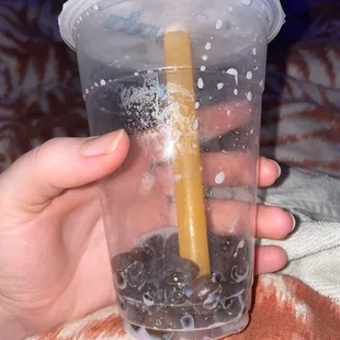 a person holding a plastic cup with a straw in it