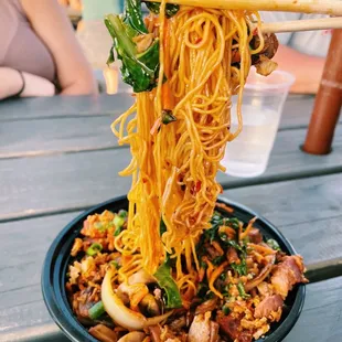 a bowl of noodles with chopsticks