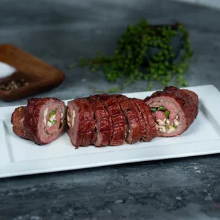 Flank steak rolled up with feta cheese, green peppers and mushrooms.