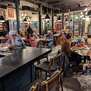 a crowded restaurant with people eating and drinking