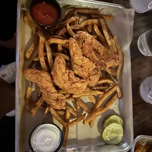 a tray of fried chicken wings and french fries