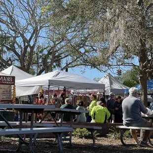 people sitting at picnic tables