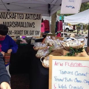a woman standing at a table with food
