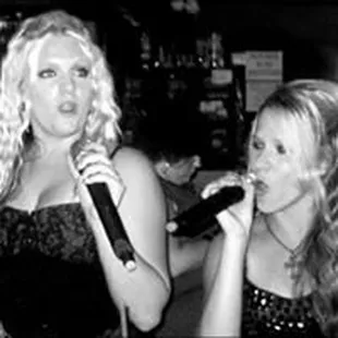 two women singing into microphones