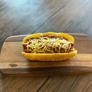 a chili dog with cheese on top