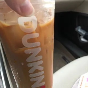  a hand holding a cup of coffee