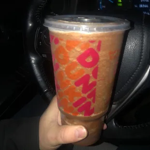  a person holding a drink in their hand