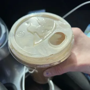  a hand holding a cup of coffee