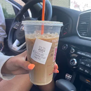  a person holding a cup of iced coffee