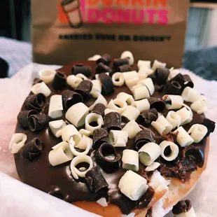  a chocolate covered doughnut with white and black toppings