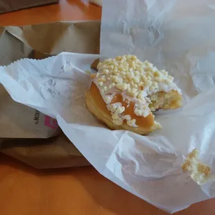  a half eaten doughnut on a piece of paper