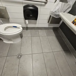  a person standing in a public bathroom
