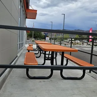  a row of picnic tables in front of a building