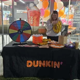  a woman behind a dunkin donut stand