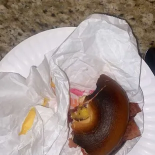 a half eaten sandwich on a paper plate