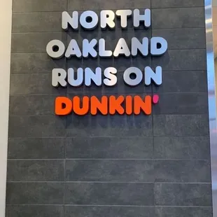  a sign that says north oakland runs on dunkin
