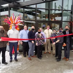  a group of people cutting a ribbon