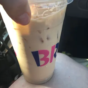  a hand holding a cup of coffee