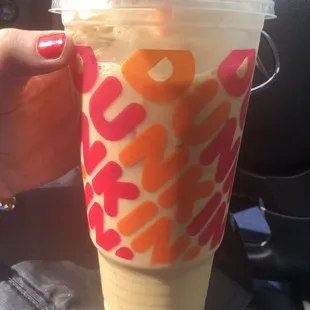  a hand holding a plastic cup with a straw