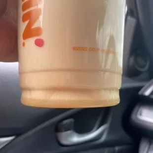  a hand holding a cup of coffee