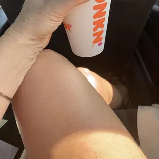  a hand holding a cup of coffee