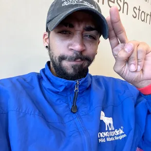  a man wearing a blue jacket and a hat