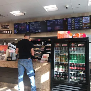  a man standing at a counter in a restaurant