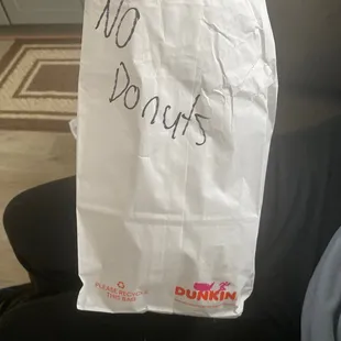  a person holding a bag of donuts