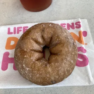  a donut on a napkin next to a drink