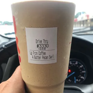  a hand holding a cup of coffee