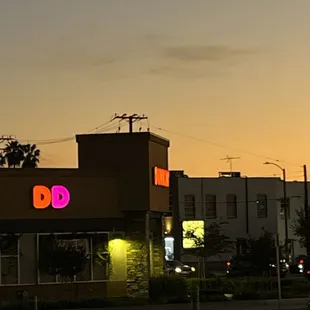  the neon sign of a dunkin donut shop