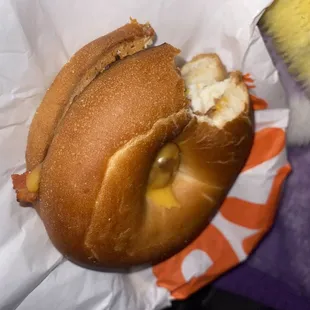 a hot dog in a bun with a bite taken out of it